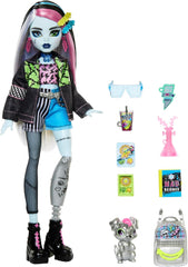 Păpușa Monster High Frankie Stein în jachetă de blugi și pantaloni scurți, include și cățelușa ei Watzie și accesorii precum un rucsac, o gustare și un caiet, HXH73